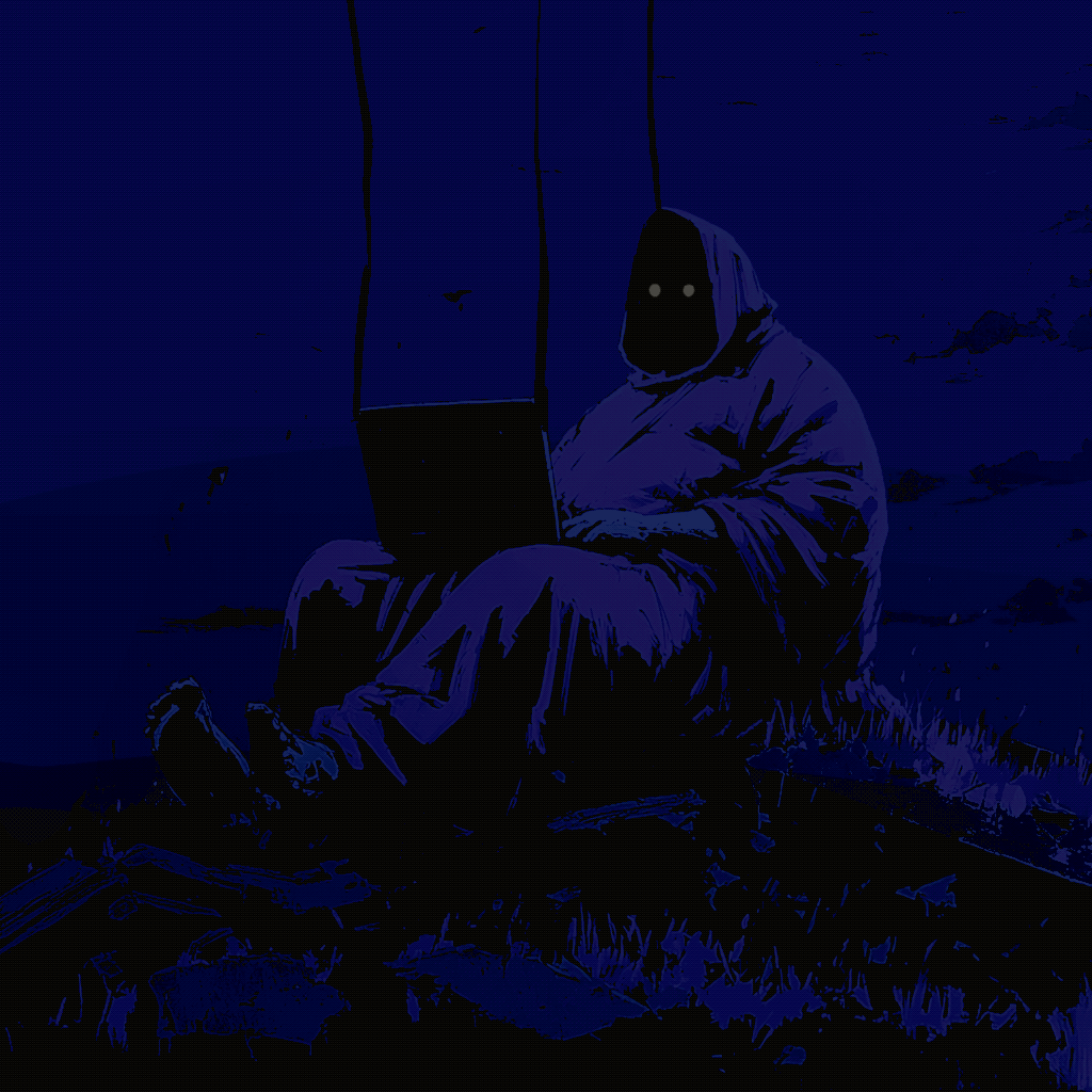 A hooded figure sits in total darkness, face lit only by a laptop